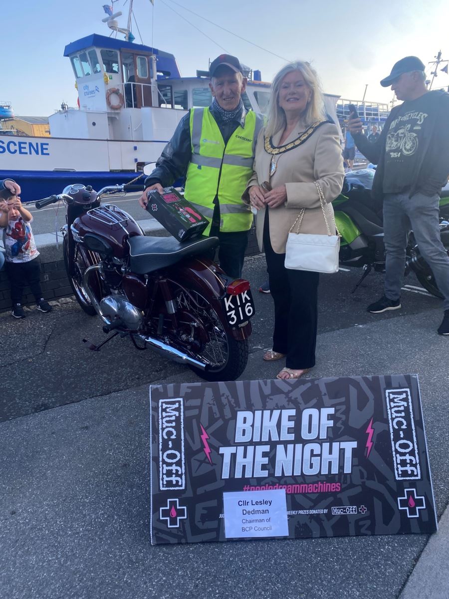 Man accepting award from woman for winning bike of the night at Poole quay